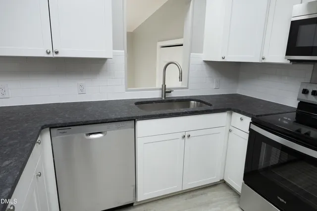 a kitchen with white cabinets and a stove