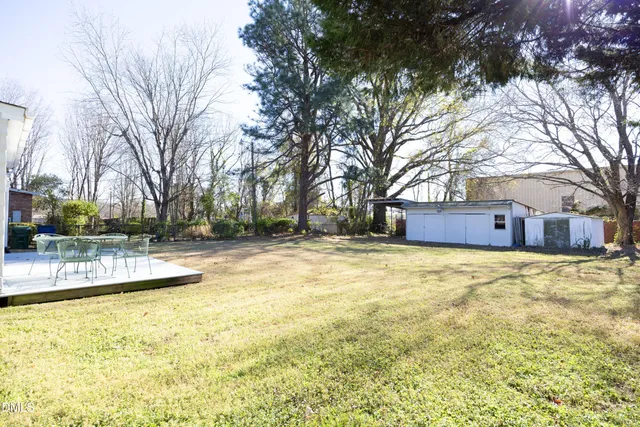 a backyard of a house with large trees and a small yard