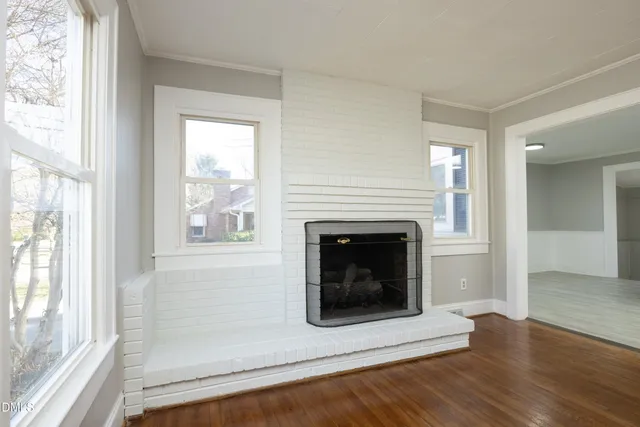 a living room with a fireplace and a floor to ceiling window