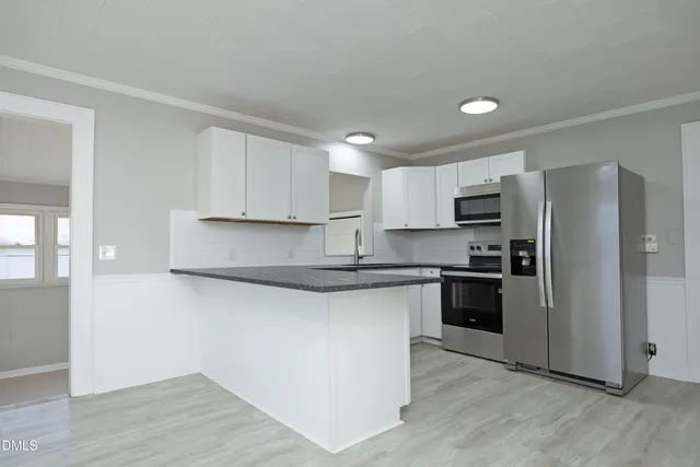 a kitchen with granite countertop a refrigerator and a stove top oven
