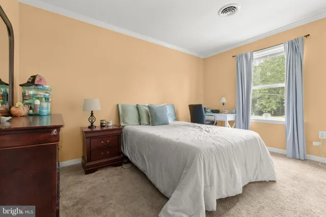 a bedroom with a bed and a lamp on dresser