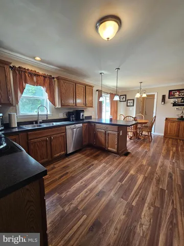 a kitchen with stainless steel appliances granite countertop a sink dishwasher stove and wooden floor