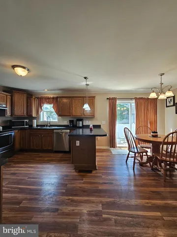 a kitchen with stainless steel appliances kitchen island granite countertop a stove and a refrigerator