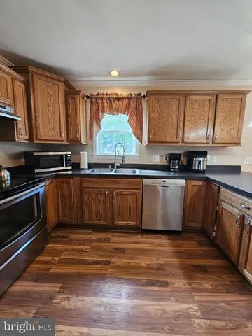 a kitchen with stainless steel appliances granite countertop a stove a sink and a white cabinets