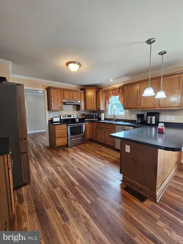 a kitchen with stainless steel appliances granite countertop a stove a sink dishwasher and a microwave oven with cabinets