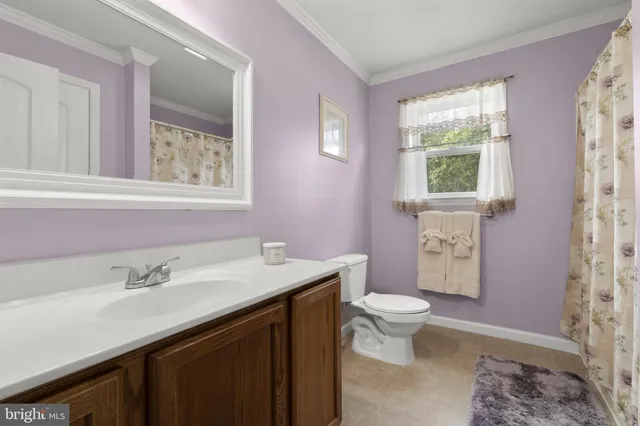 a bathroom with a sink a toilet and a window