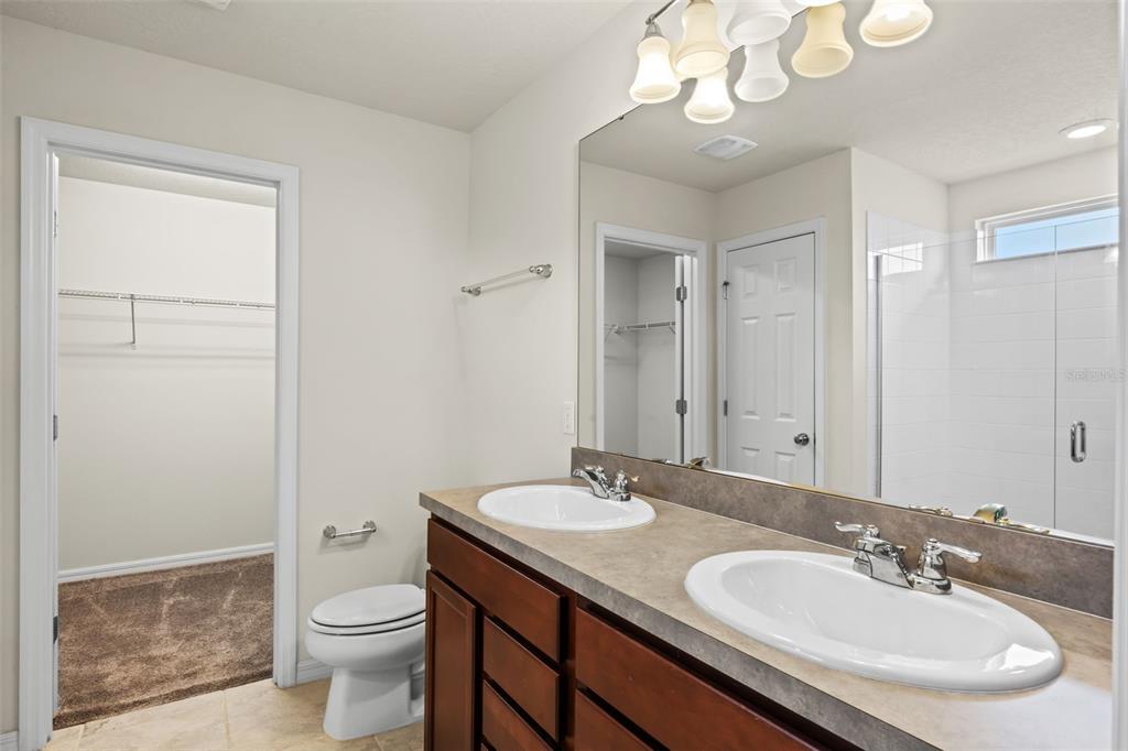 5164 Chickadee Street St. Cloud, FL 34771 - Photo 14 of 35 a bathroom with a sink a toilet and a mirror