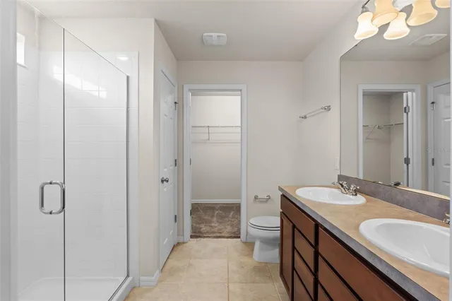 a bathroom with a granite countertop sink a toilet and shower