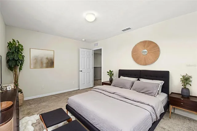 a bedroom with a bed and a potted plant