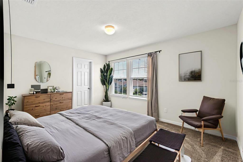 5164 Chickadee Street St. Cloud, FL 34771 - Photo 18 of 35 a bedroom with a bed and wooden floor