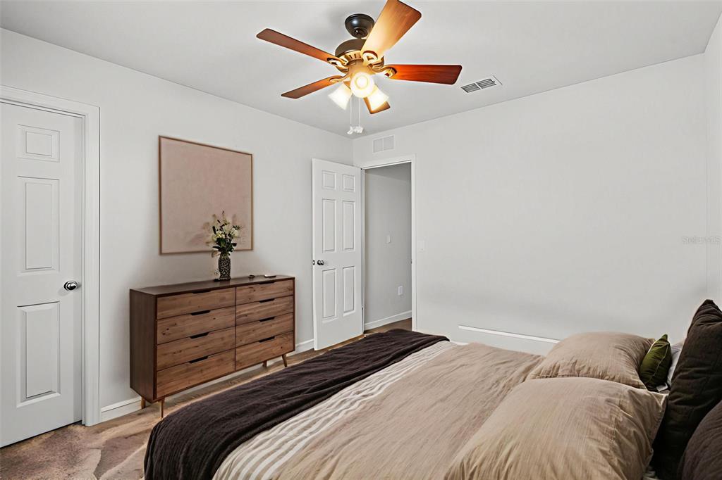 5164 Chickadee Street St. Cloud, FL 34771 - Photo 21 of 35 a bedroom with a bed and a chandelier