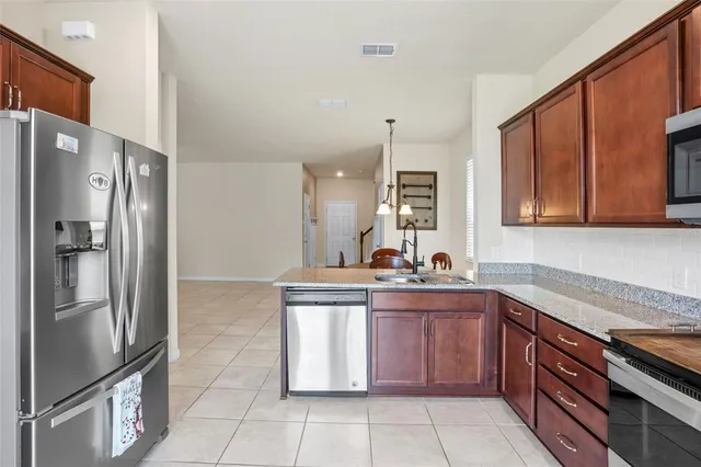a kitchen with stainless steel appliances granite countertop a refrigerator and a sink