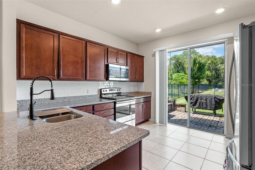 5164 Chickadee Street St. Cloud, FL 34771 - Photo 7 of 35 a kitchen with a stove a sink and a microwave