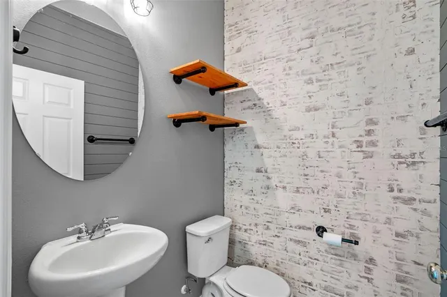 a bathroom with a sink a toilet and mirror