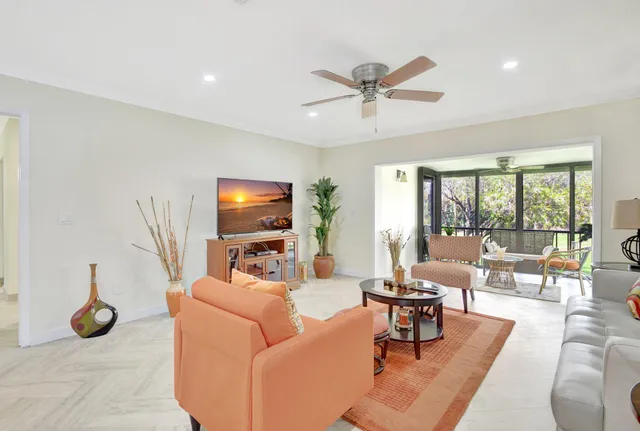 a living room with furniture and a floor to ceiling window