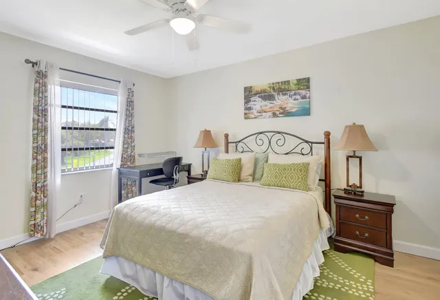 a bedroom with a bed a table and painting on the wall