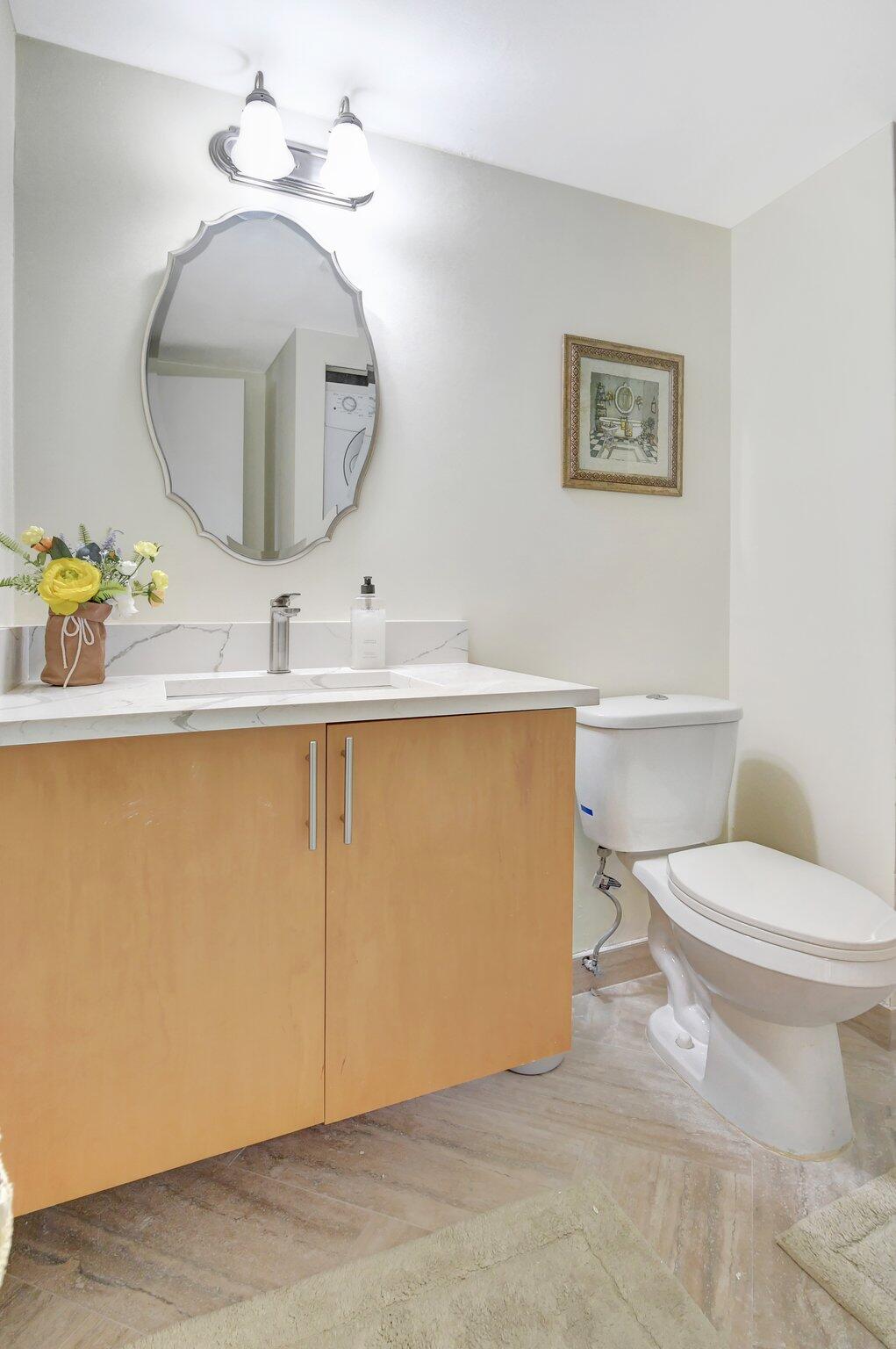 21209 Lago Circle, Unit 12G Boca Raton, FL 33433 - Photo 29 of 39 a bathroom with a toilet a sink and mirror