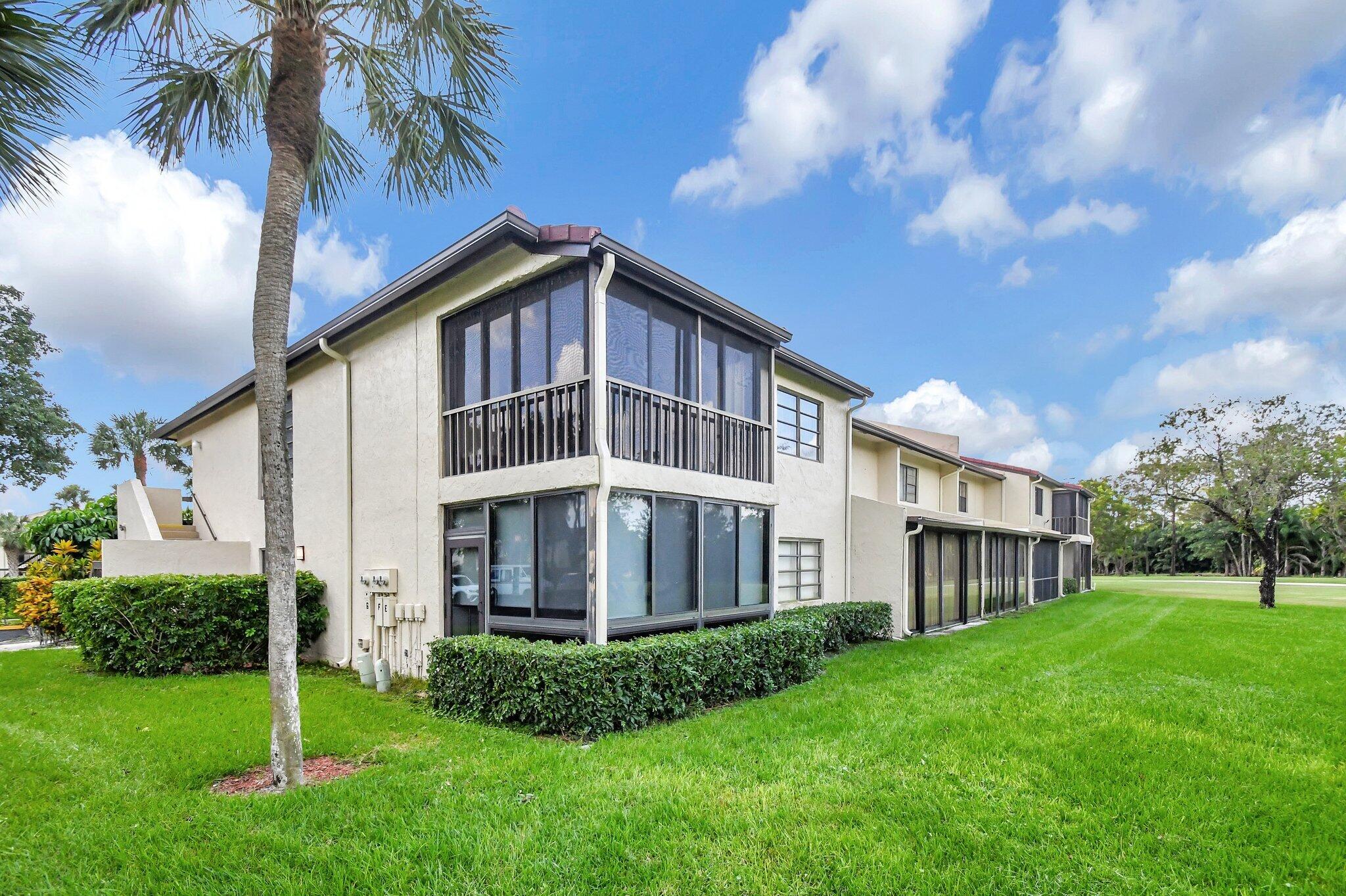 21209 Lago Circle, Unit 12G Boca Raton, FL 33433 - Photo 4 of 39 a front view of a house with a garden and plants