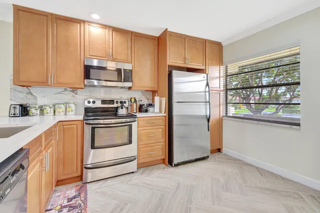 a kitchen with stainless steel appliances white cabinets and a refrigerator