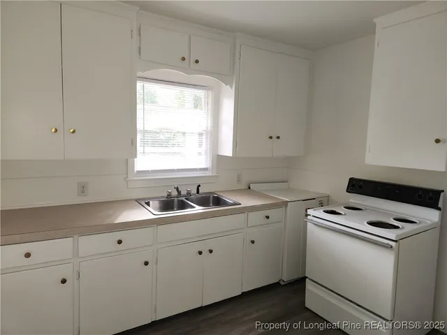 a kitchen with cabinets appliances a sink and a window
