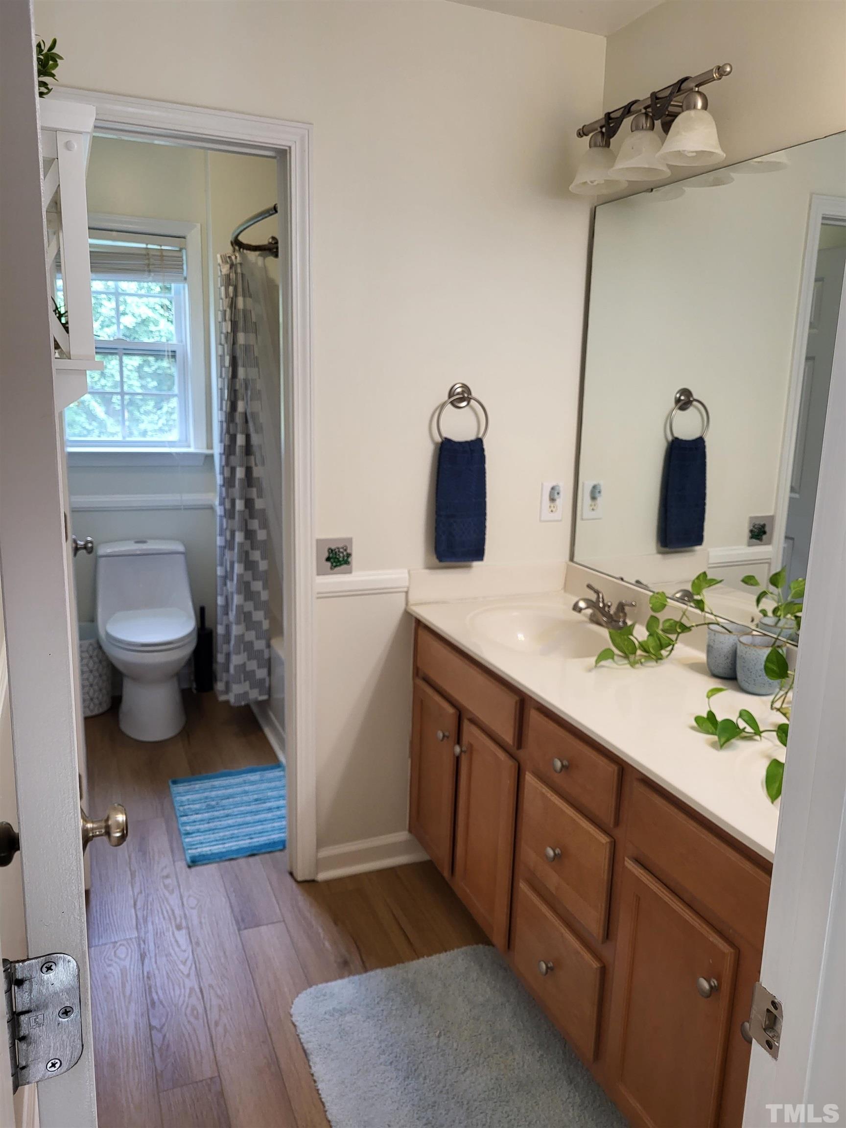 a spacious bathroom with a sink a toilet and a mirror