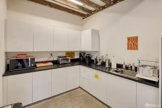 a kitchen with stainless steel appliances a sink a stove and white cabinets
