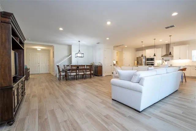 a view of a dining room and livingroom with furniture wooden floor a chandelier