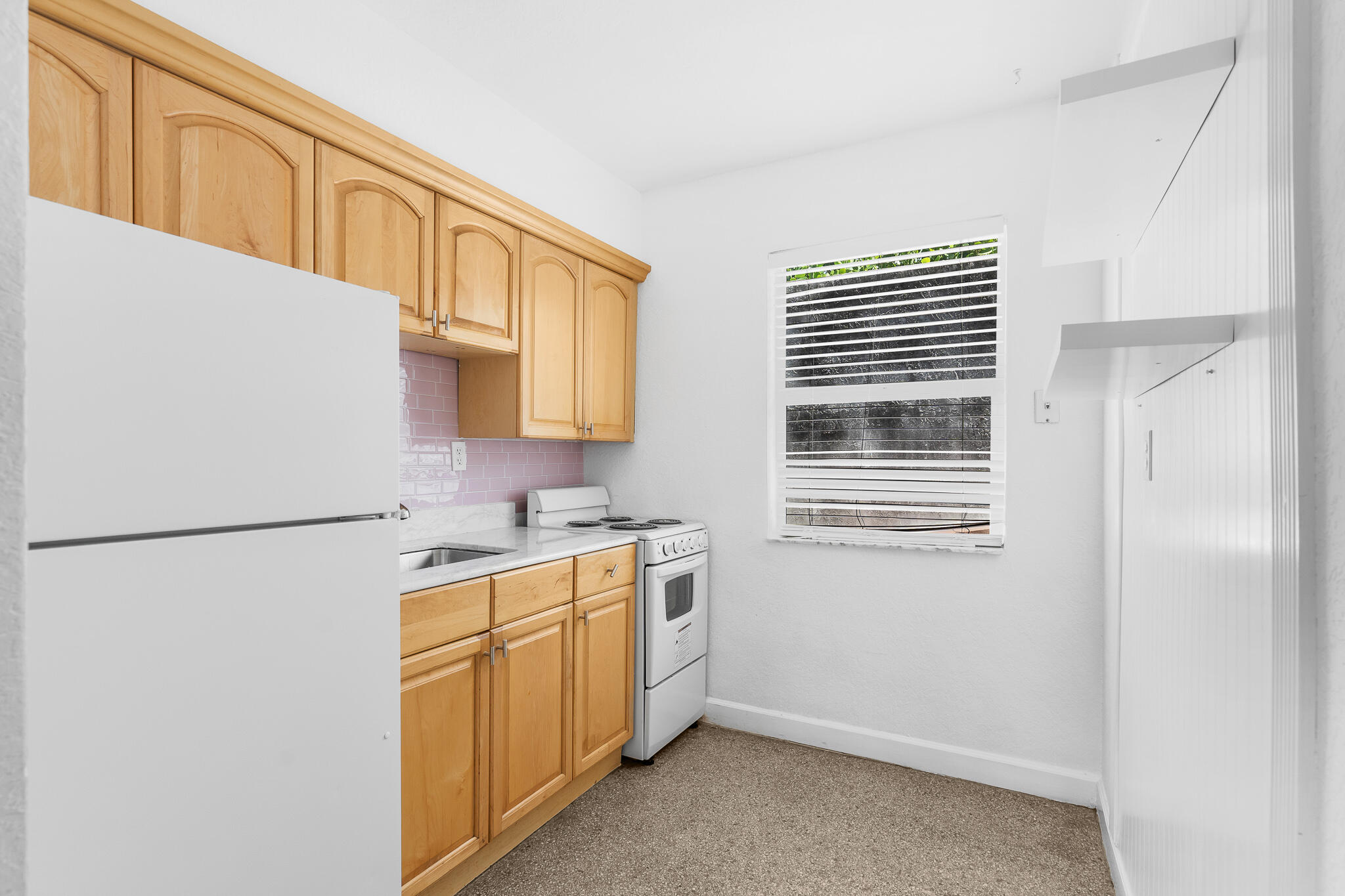 11 Tropical Drive, Unit 3 Ocean Ridge, FL 33435 - Photo 9 of 15 a kitchen with a refrigerator a stove a sink and cabinets