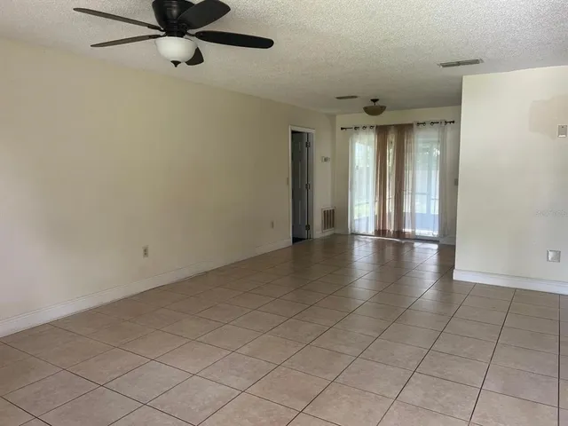 a view of a livingroom with a ceiling fan and window