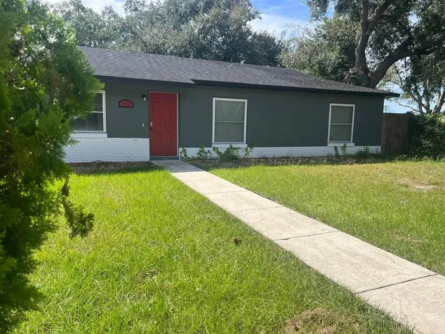 a front view of a house with yard and green space
