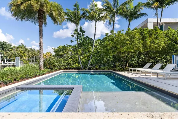 an aerial view of ocean and residential houses with outdoor space