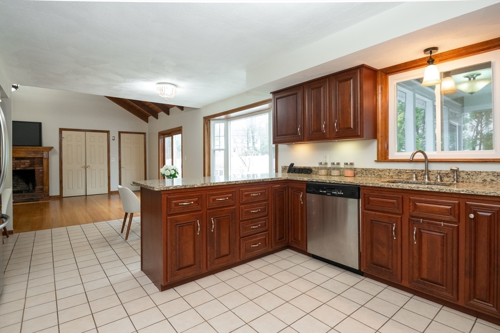 159 Willow Street Acton, MA 01720 - Photo 16 of 34 a kitchen with stainless steel appliances granite countertop a sink counter space cabinets and a window