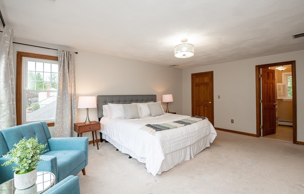 159 Willow Street Acton, MA 01720 - Photo 3 of 34 a spacious bedroom with a bed and a couch