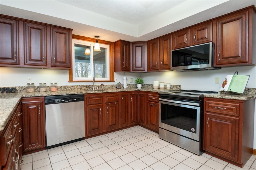 159 Willow Street Acton, MA 01720 - Photo 10 of 34 a kitchen with granite countertop a stove top oven microwave and cabinets