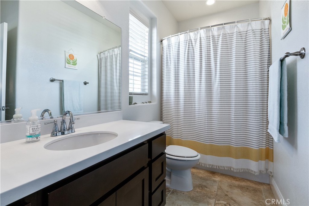9354 Riberena Circle Atascadero, CA 93422 - Photo 25 of 47 a bathroom with a sink a toilet a mirror and shower curtain