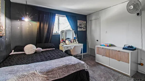 a bedroom with a bed and large windows