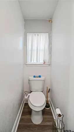 a white toilet sitting in a bathroom next to a window