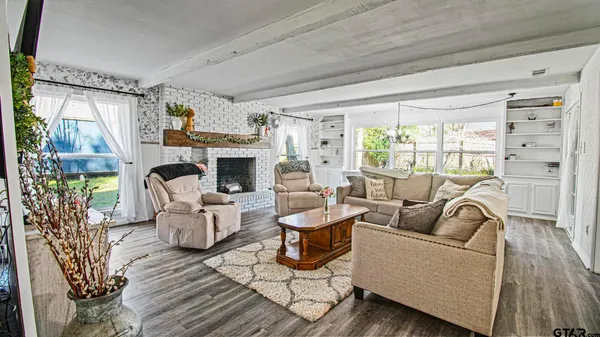 a living room with furniture fireplace and a large window