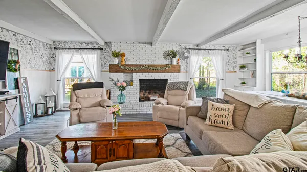 a living room with furniture fireplace and a large window
