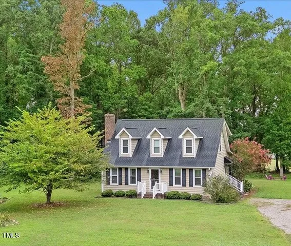 a view of a building with a garden and trees