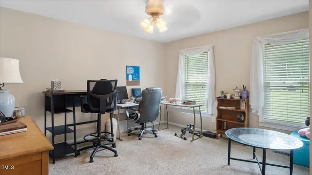 a view of a workspace with furniture and a window