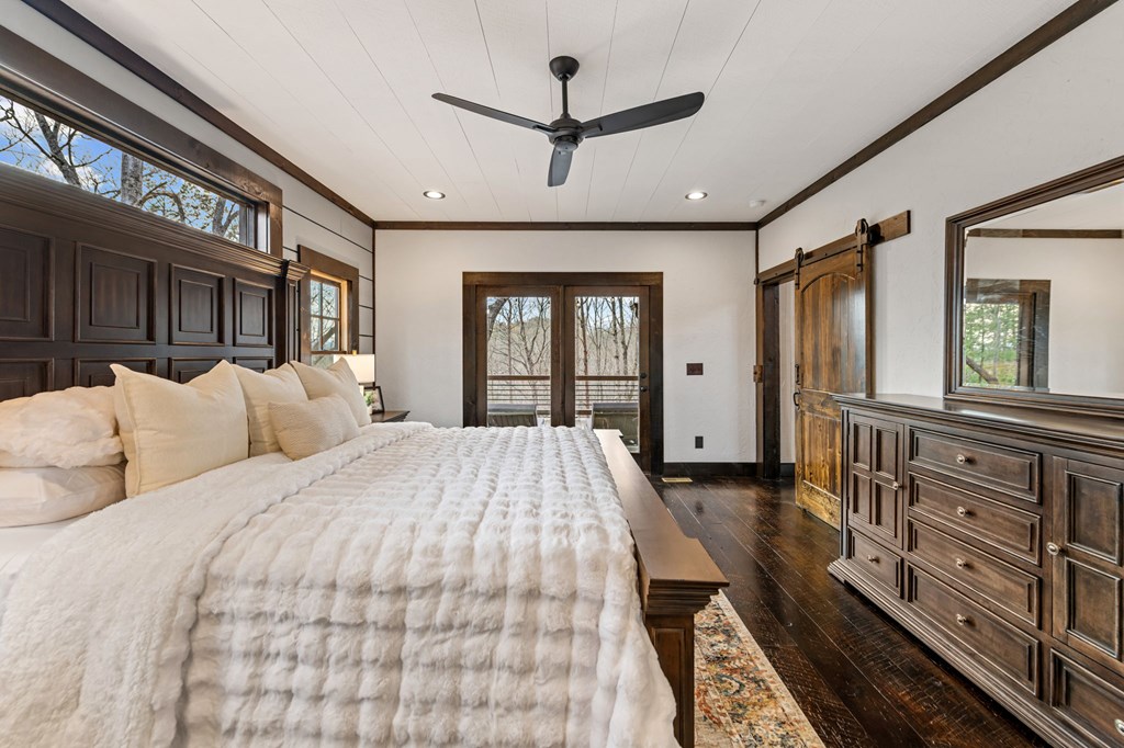 895 Price Road Blue Ridge, GA 30513 - Photo 29 of 140 a spacious bedroom with a large bed a chandelier and windows