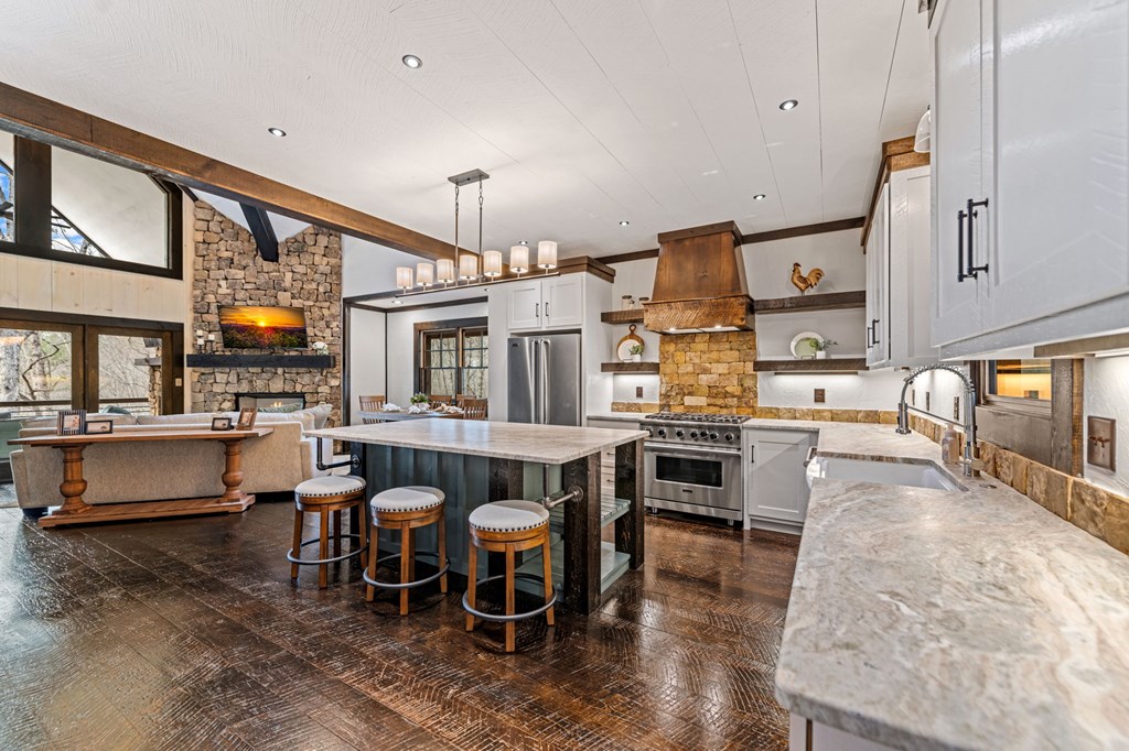 895 Price Road Blue Ridge, GA 30513 - Photo 6 of 140 a kitchen with stainless steel appliances granite countertop a stove top oven a sink a dining table and chairs with wooden floor