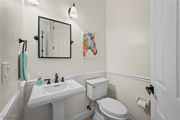 a white toilet sitting next to a bathroom sink