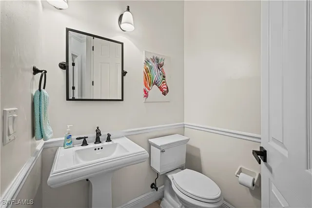 a white toilet sitting next to a bathroom sink