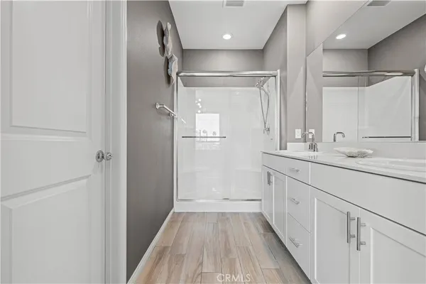 a bathroom with a double vanity sink mirror and shower
