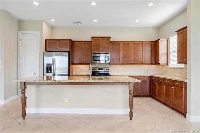 a kitchen with stainless steel appliances granite countertop a stove top oven a sink and dishwasher