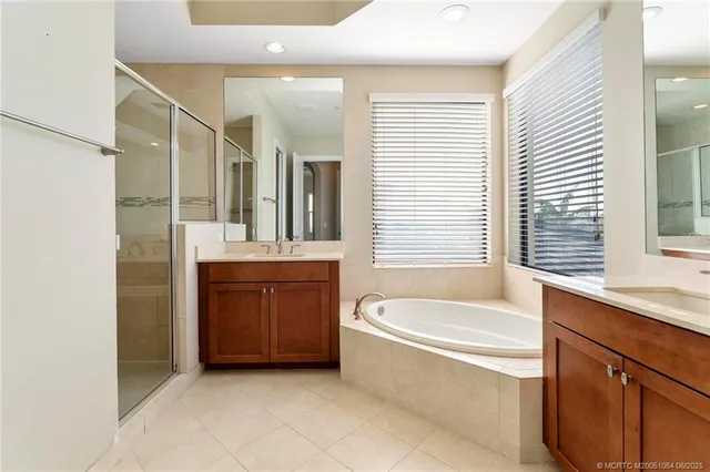 a bathroom with a tub sink and mirror
