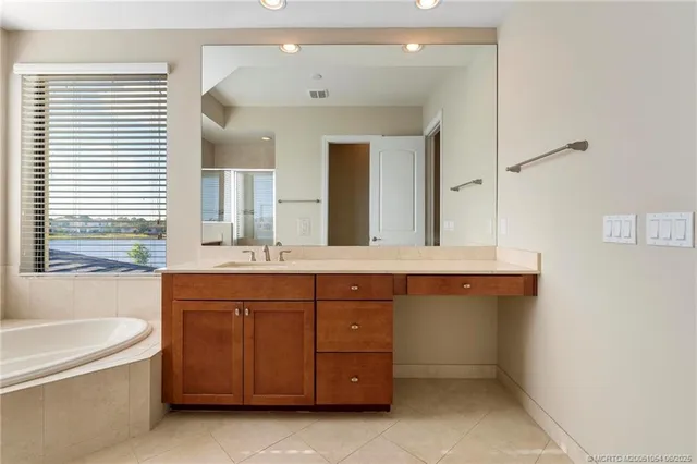 a bathroom with a granite countertop sink a toilet a mirror and bathtub