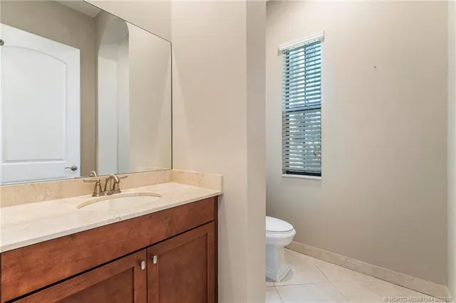 a bathroom with a sink a toilet and a large mirror